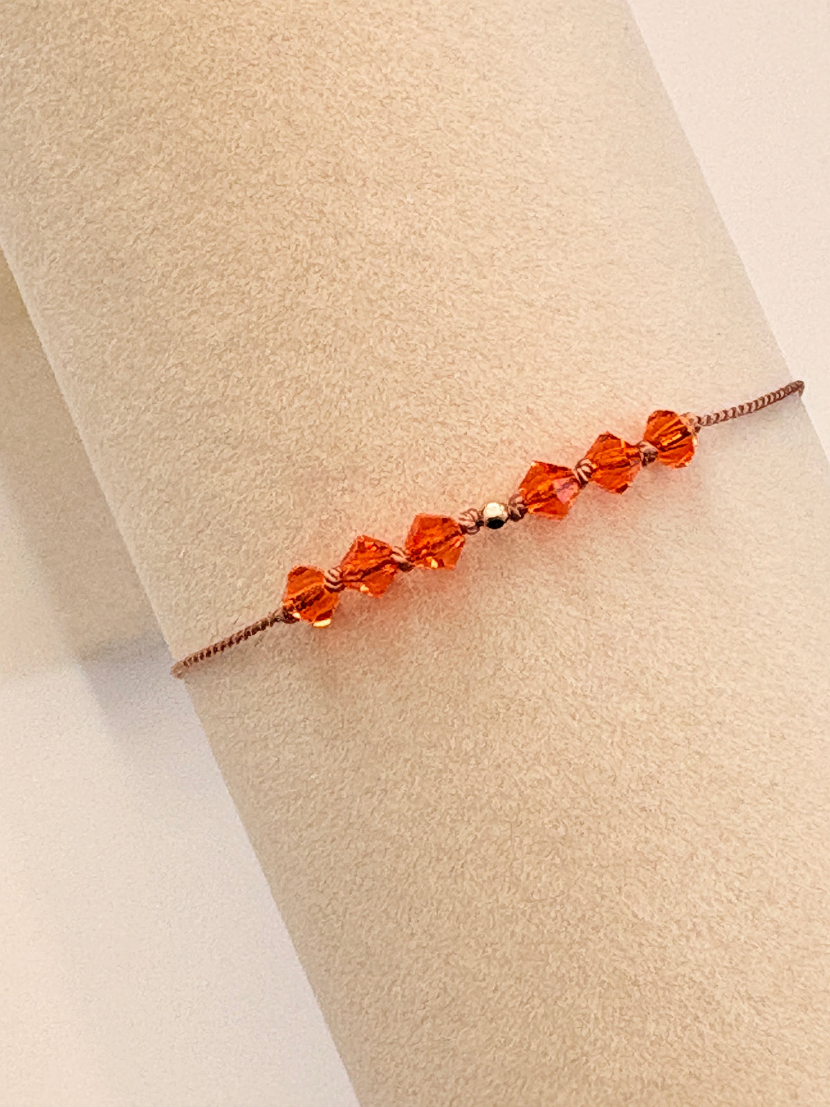 Radiant Hope bracelet displayed on a beige cream T-stand, showing Sun crystals and gold-filled details.