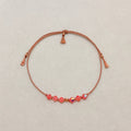 Golden Memory adjustable bracelet with Rose Peach AB crystals, beige silk cord, and gold-filled details on a soft ivory velvet background.
