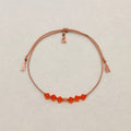 Radiant Hope adjustable bracelet with vibrant Sun crystals, beige silk cord, and gold-filled details on a soft ivory velvet background.